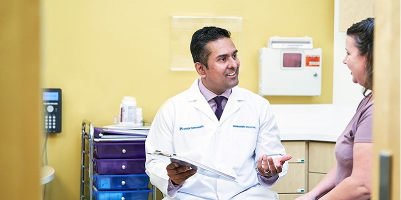 physician speaking with patient in exam room