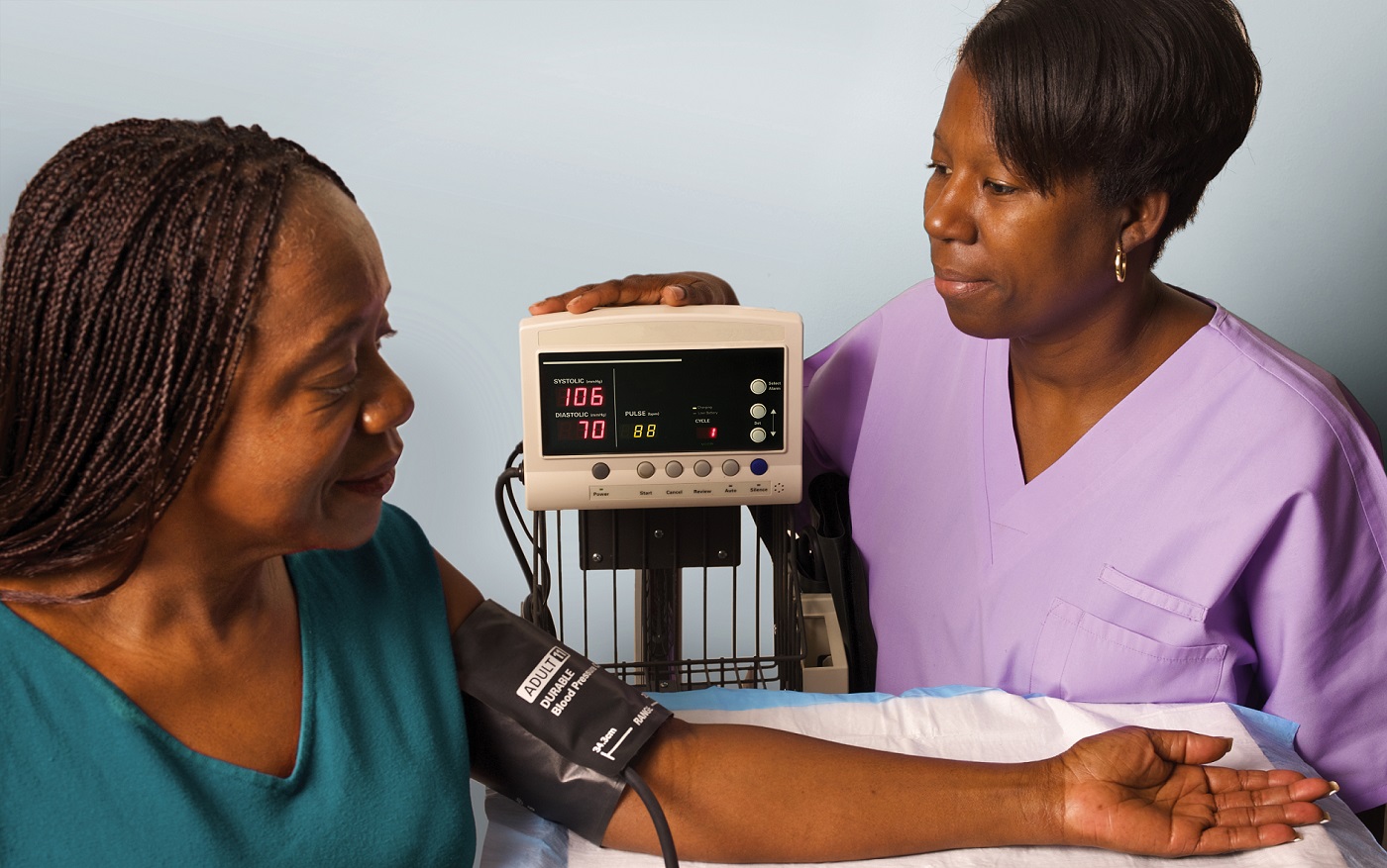 female medical assistant taking female patient's blood pressure