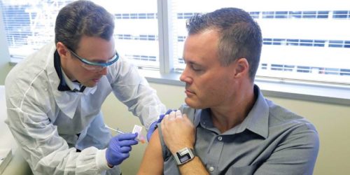 Male Physician Giving Male Test Subject An Experimental Vaccine