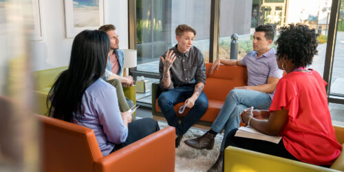 group sitting in circle on coaches and chairs